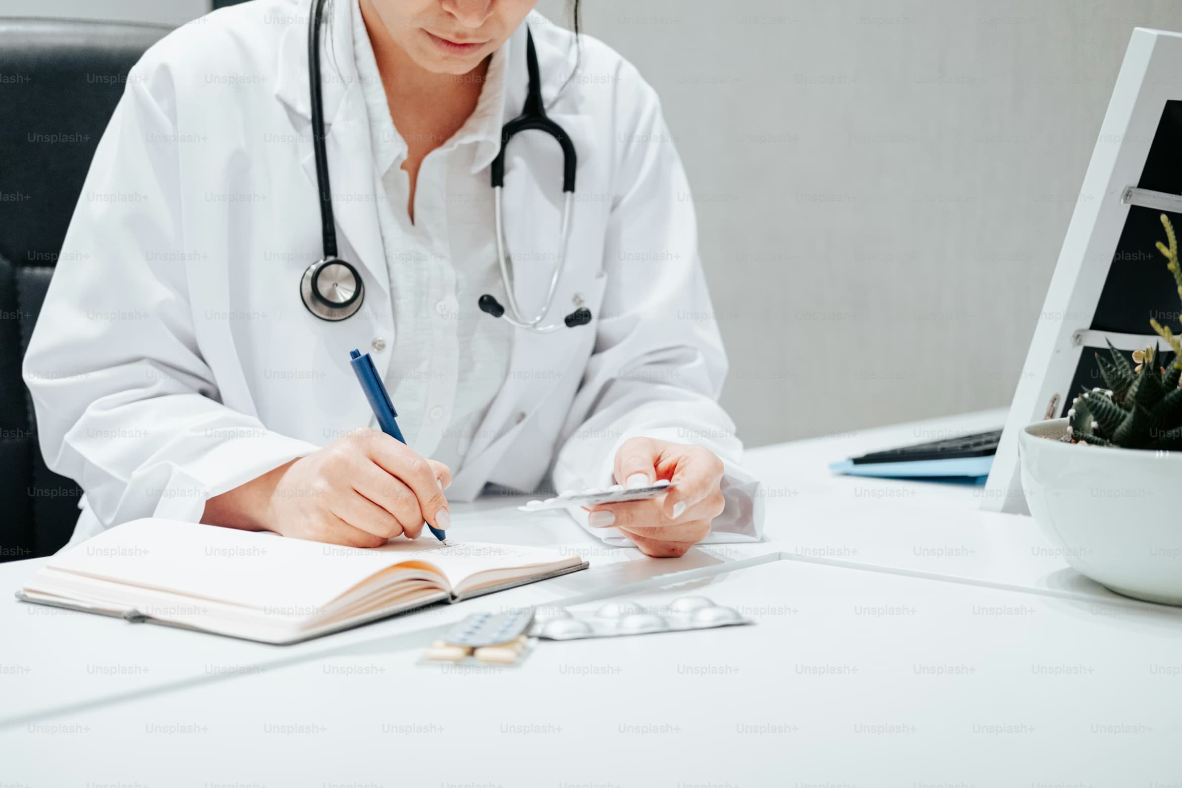 Female doctor in white coat writing notes
